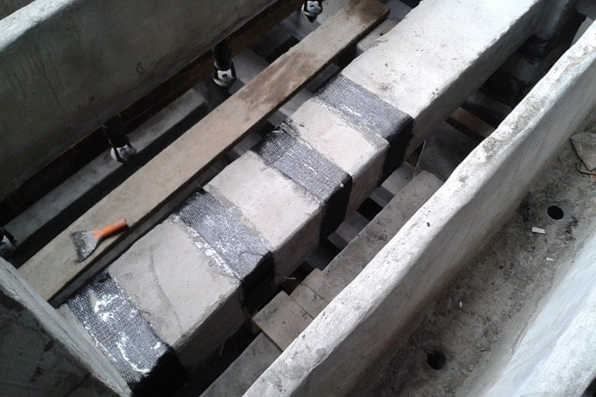 Strengthening a beam by wrapping it with carbon fibre